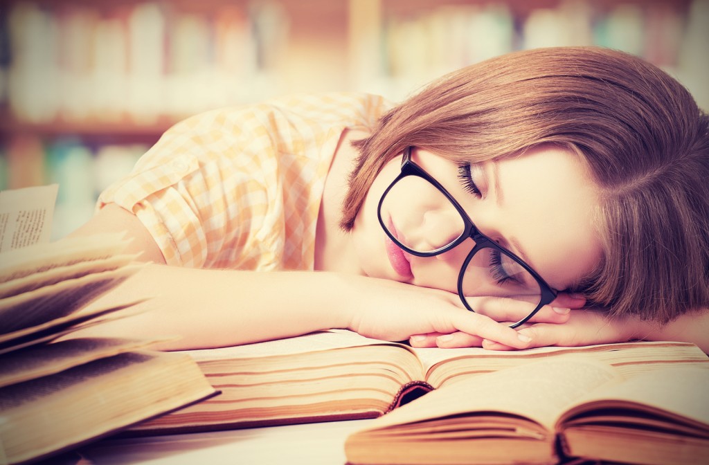tired student girl with glasses sleeping on the books in the library
** Note: Shallow depth of field